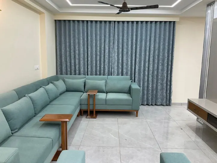 Living room with custom blue seating, wood finishes and recessed ceiling lighting